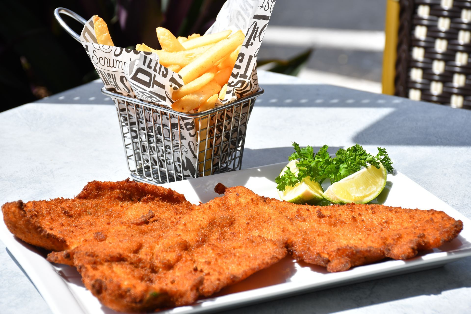 A plate of fried meat next to a plate of vegetables