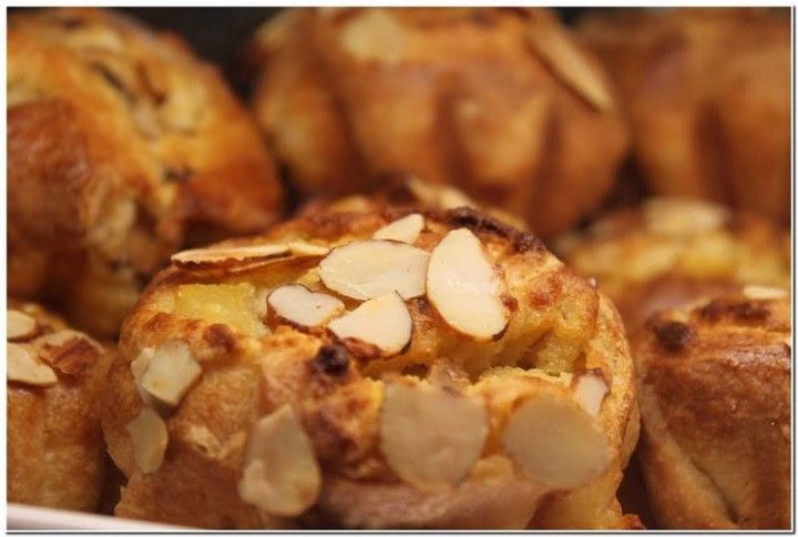 A bunch of muffins with almonds on top of them