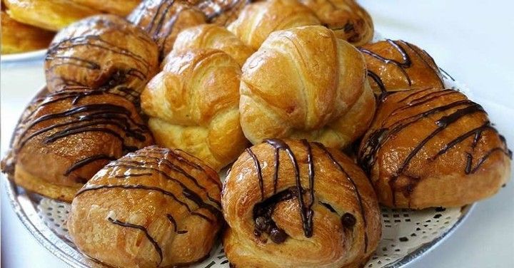 A plate of pastries with chocolate icing on them on a table.