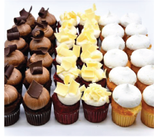 A variety of cupcakes are lined up on a white surface