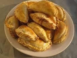 A white plate topped with a bunch of pastries on a table.