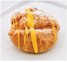 A pastry with yellow icing and powdered sugar on a white plate