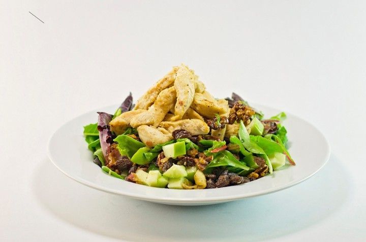 A white plate topped with a salad with chicken and vegetables.