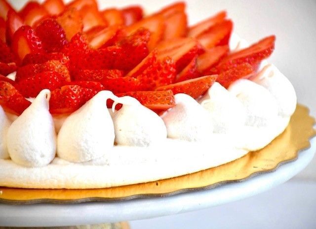 A pie with strawberries and whipped cream on top