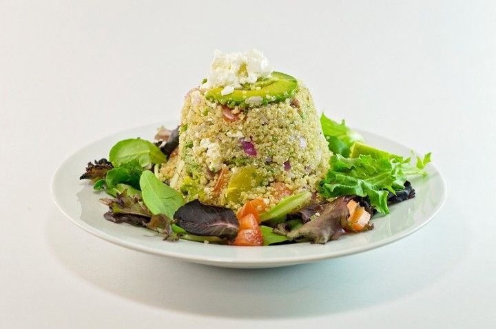 A white plate topped with a salad of rice and vegetables.