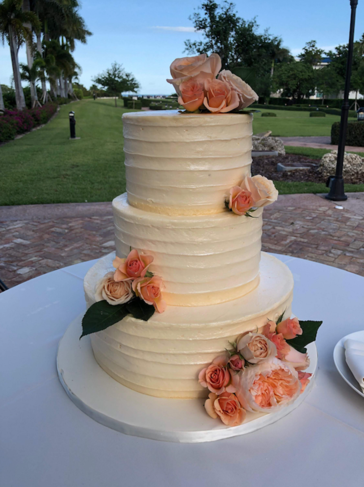 A wedding cake with flowers on top of it is sitting on a table.