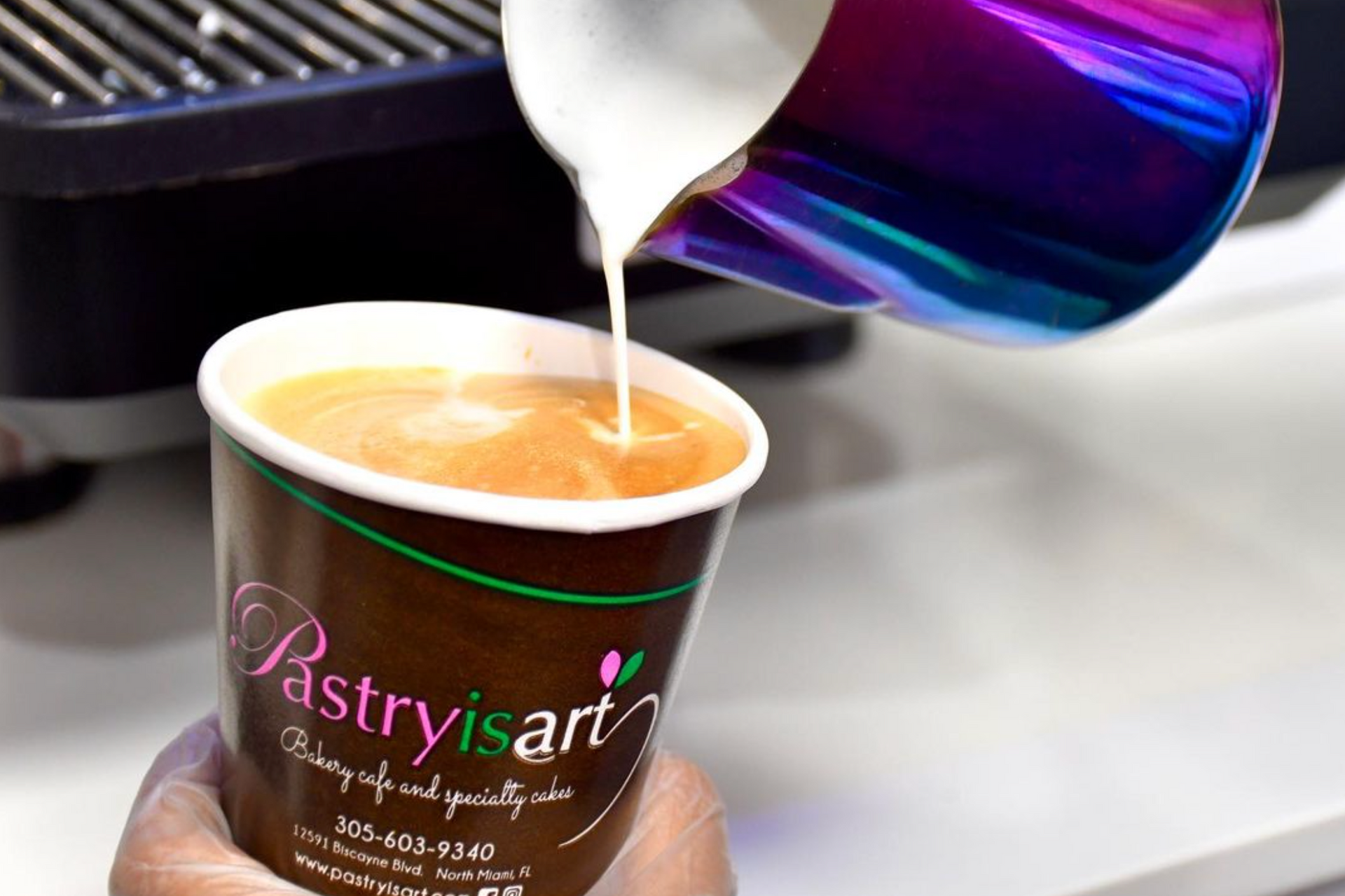 A person is pouring milk into a cup of coffee.