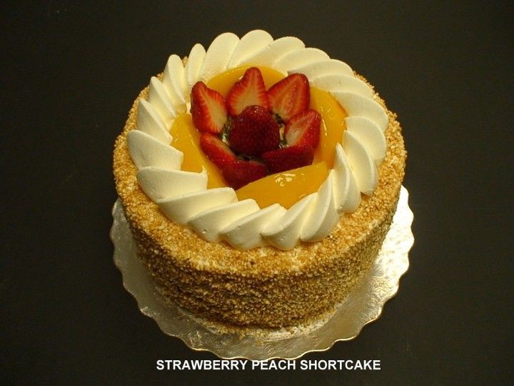 A strawberry peach shortcake with whipped cream and strawberries on top