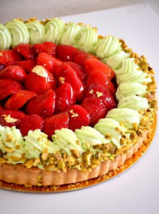 A pie with strawberries and pistachios on top