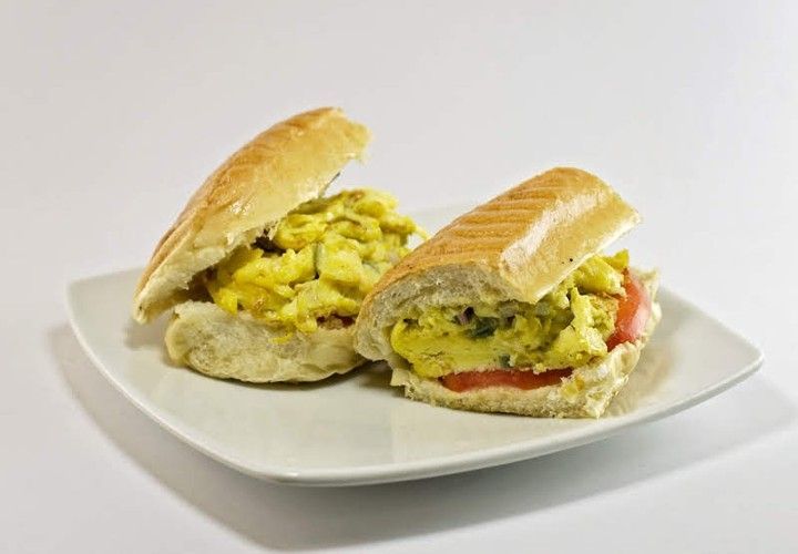 Two sandwiches are cut in half on a white plate.