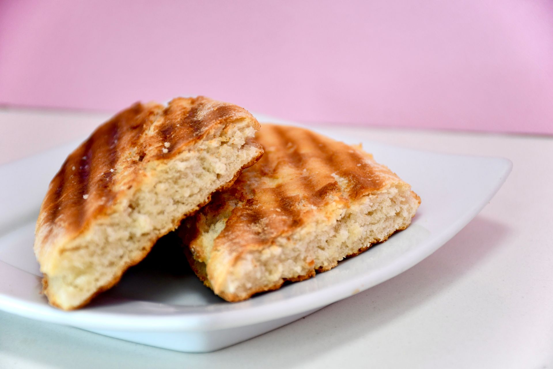 Two pieces of bread are on a white plate.