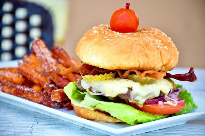 A hamburger and french fries on a white plate on a table.