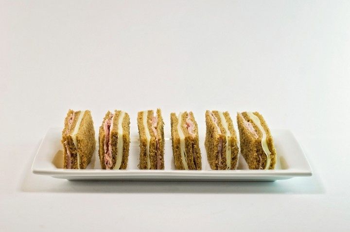A white plate topped with sandwiches on a white background.