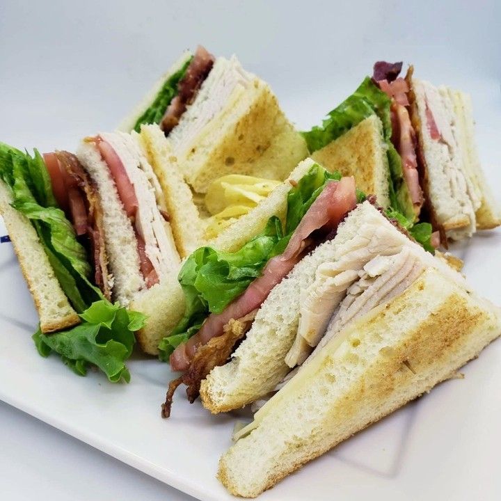 A close up of a club sandwich on a white plate