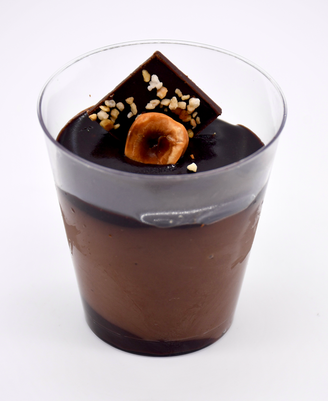 A cup of nutella mousse with nuts on top