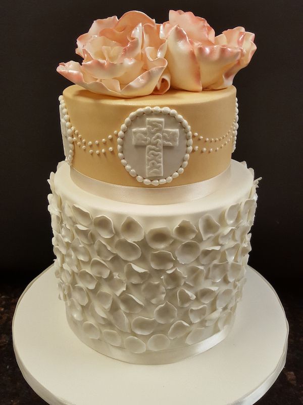 A cake with a cross and roses on top