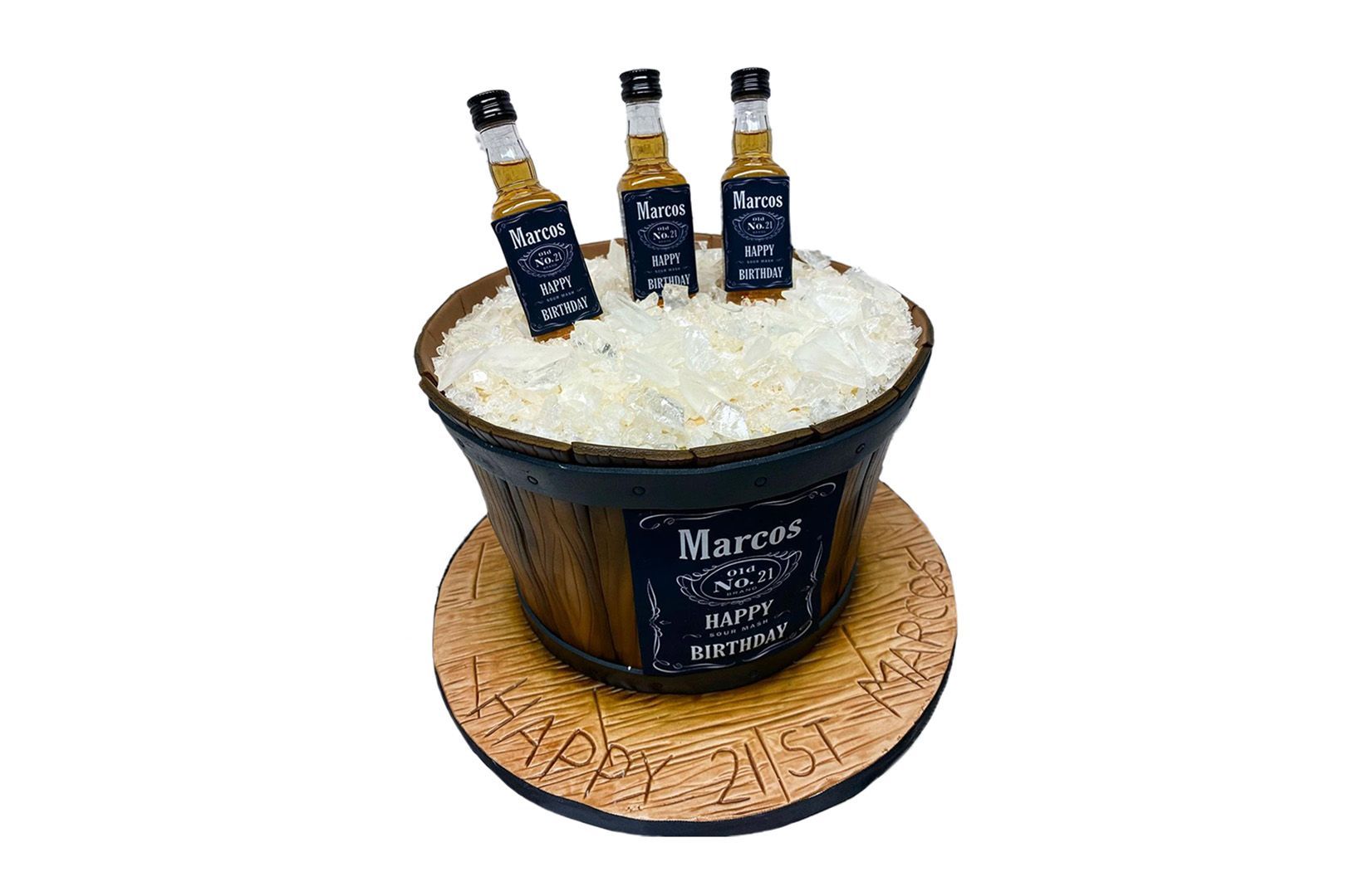 A cake in the shape of a barrel with three bottles of whiskey in it.