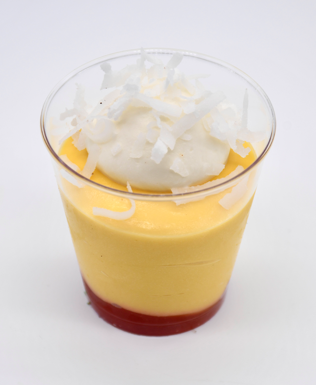 A cup of mango guava with whipped cream on top