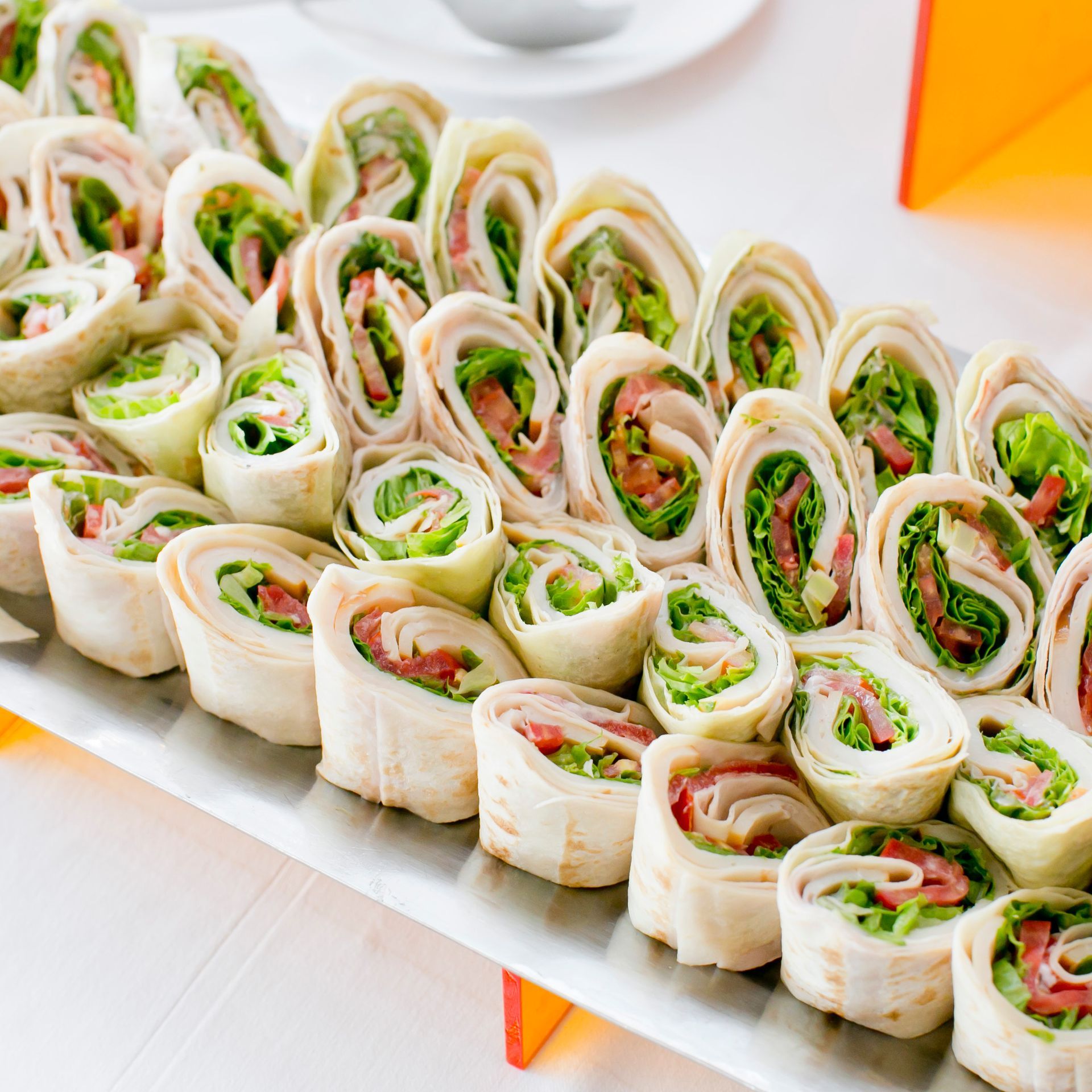 A white plate topped with tortilla rolls filled with meat and vegetables