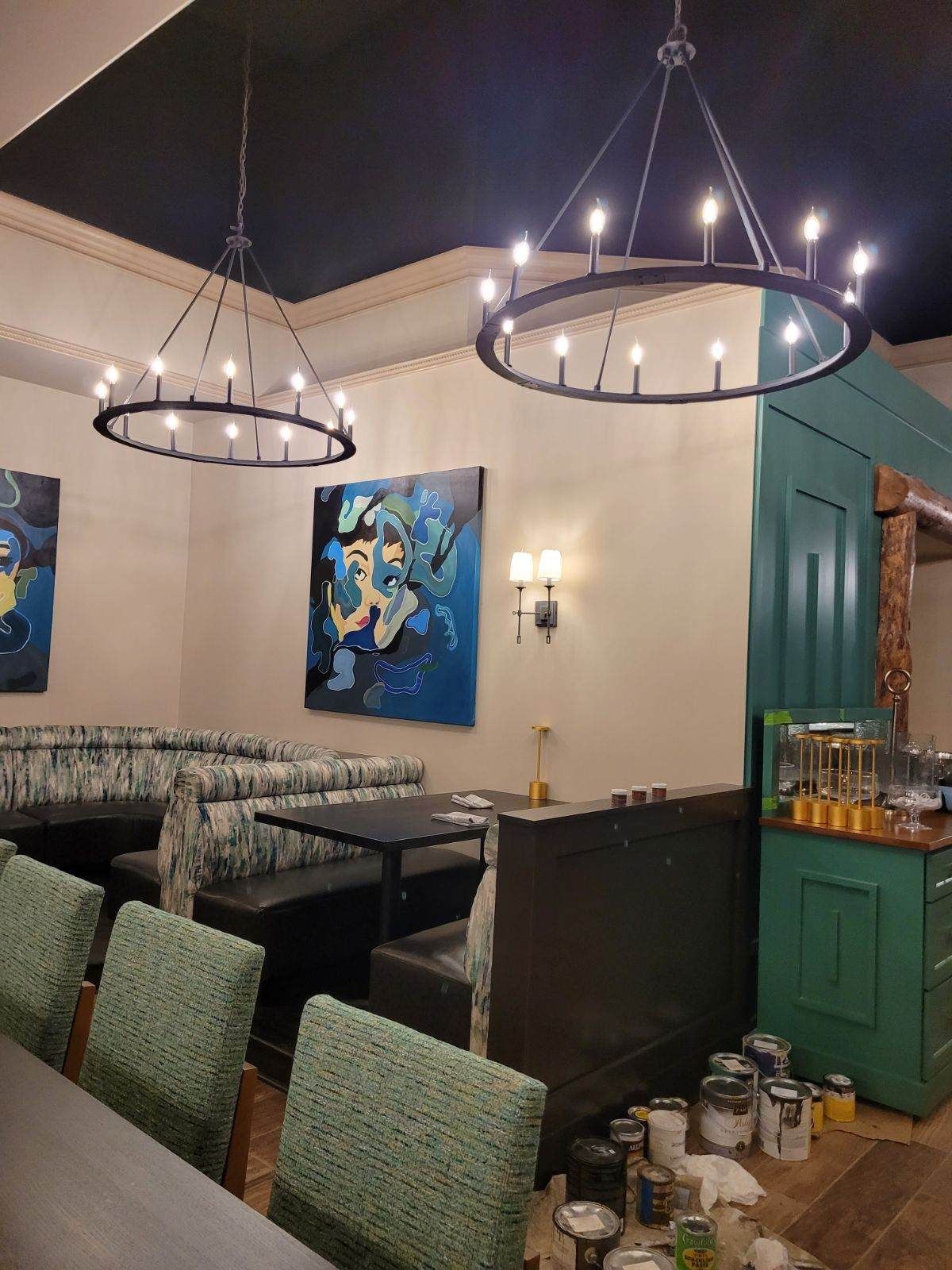 A restaurant with tables and chairs and a chandelier hanging from the ceiling.