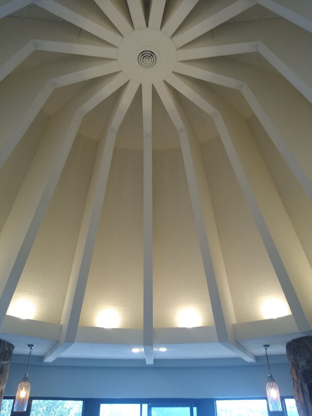 The ceiling of a room with a dome shaped ceiling.