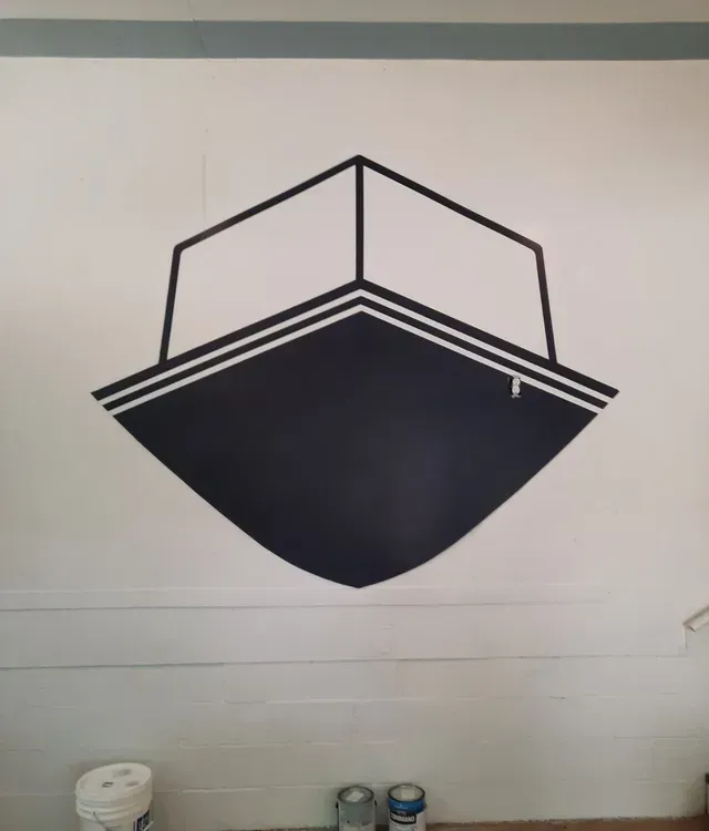 A black and white drawing of a boat on a white wall