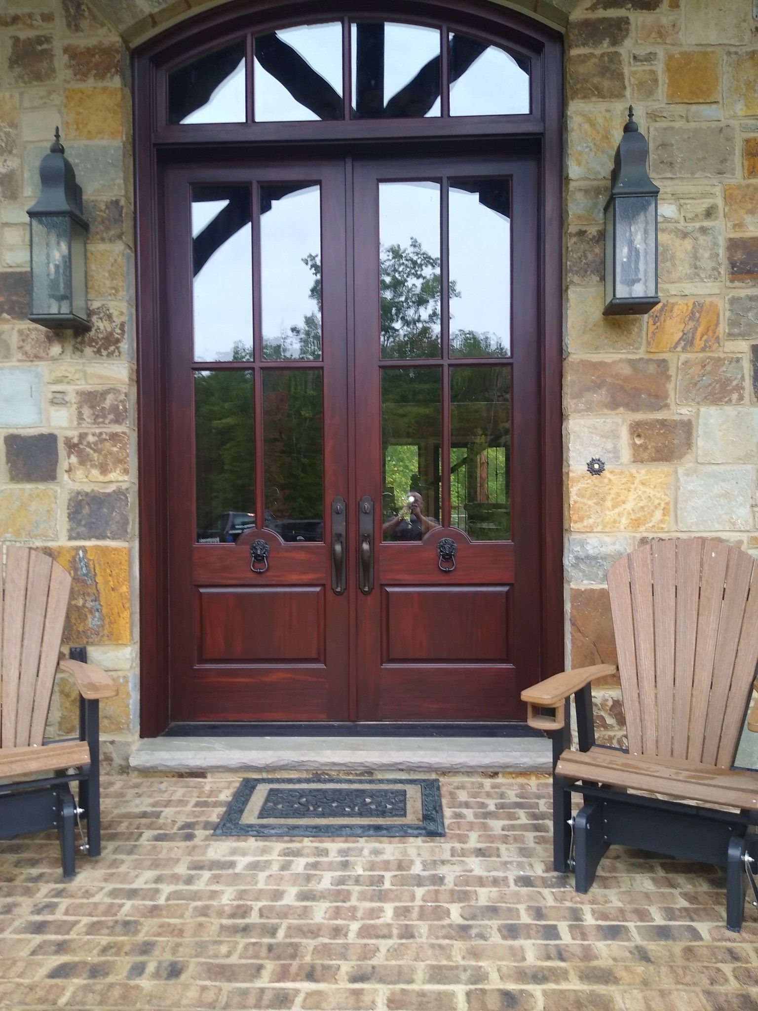 Two wooden chairs are sitting in front of a wooden door