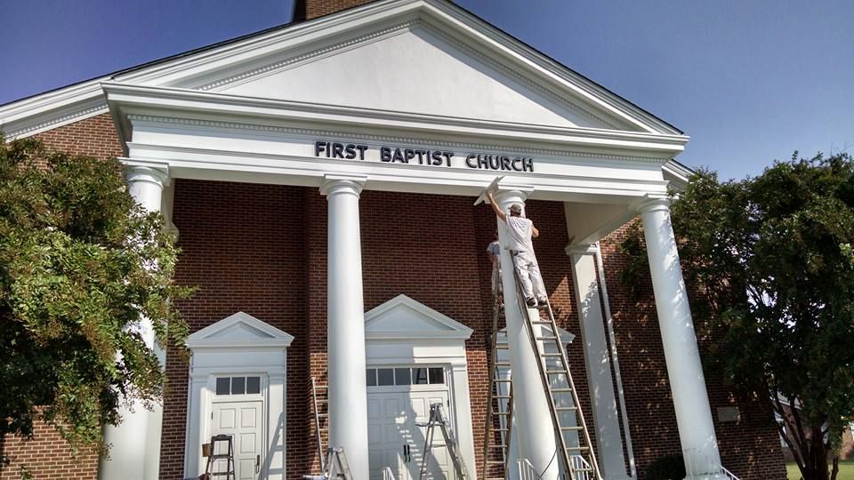 A church with a sign that says first baptist church