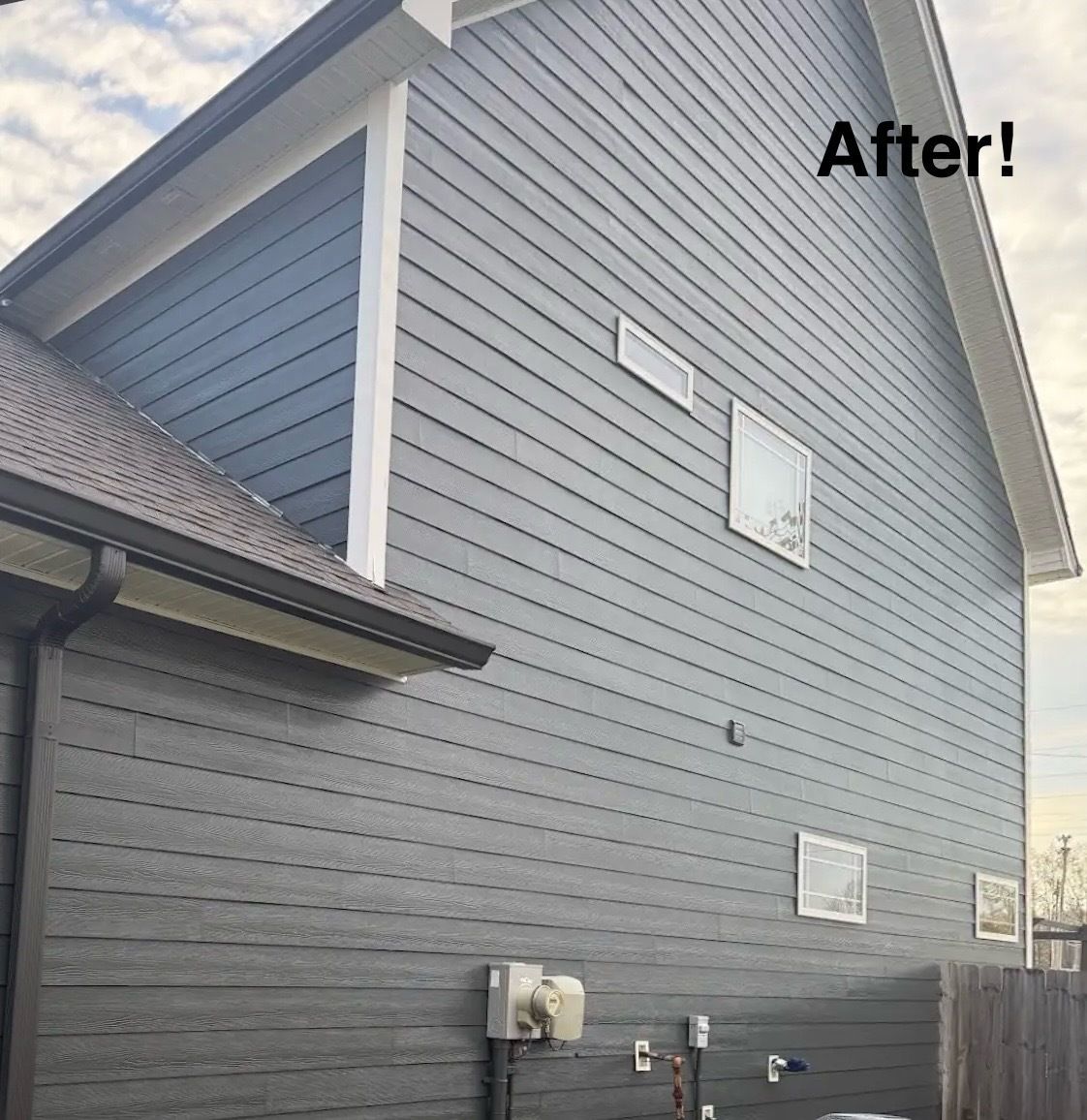 A house with a gray siding and white trim is shown after being painted.