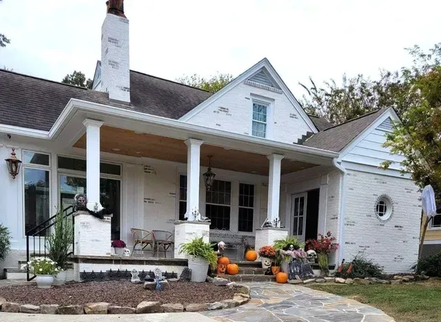 A white house with a porch decorated for halloween