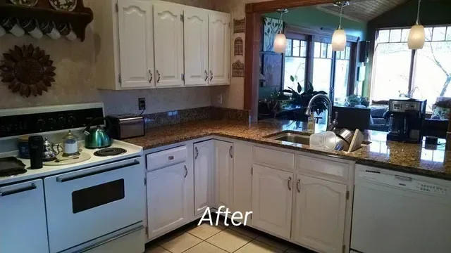 A kitchen with white cabinets and granite counter tops is shown after being remodeled