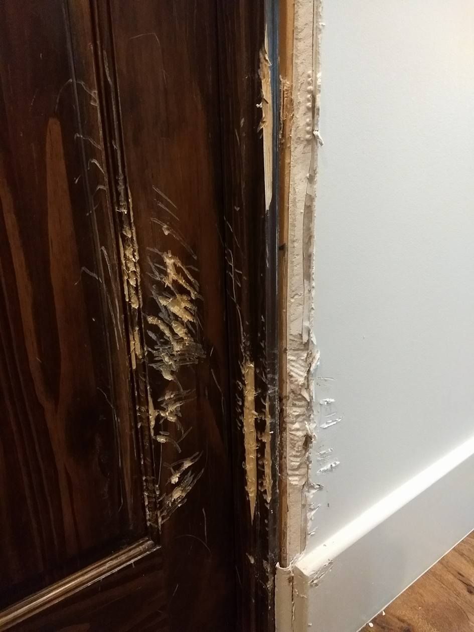 A close up of a door with peeling paint on it.