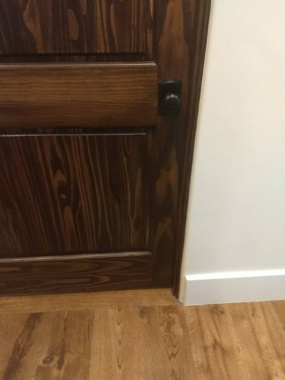A close up of a wooden door with a black knob