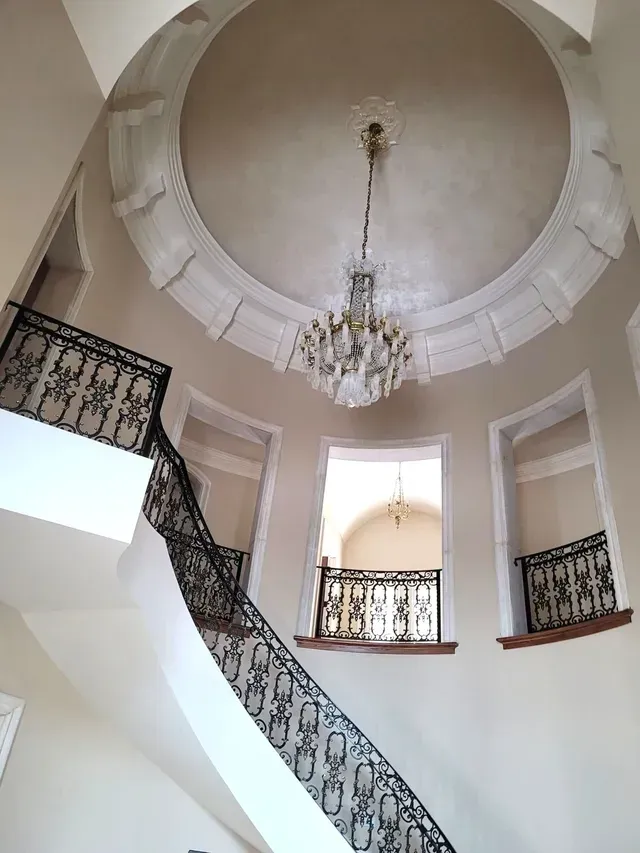 A spiral staircase with a chandelier hanging from the ceiling