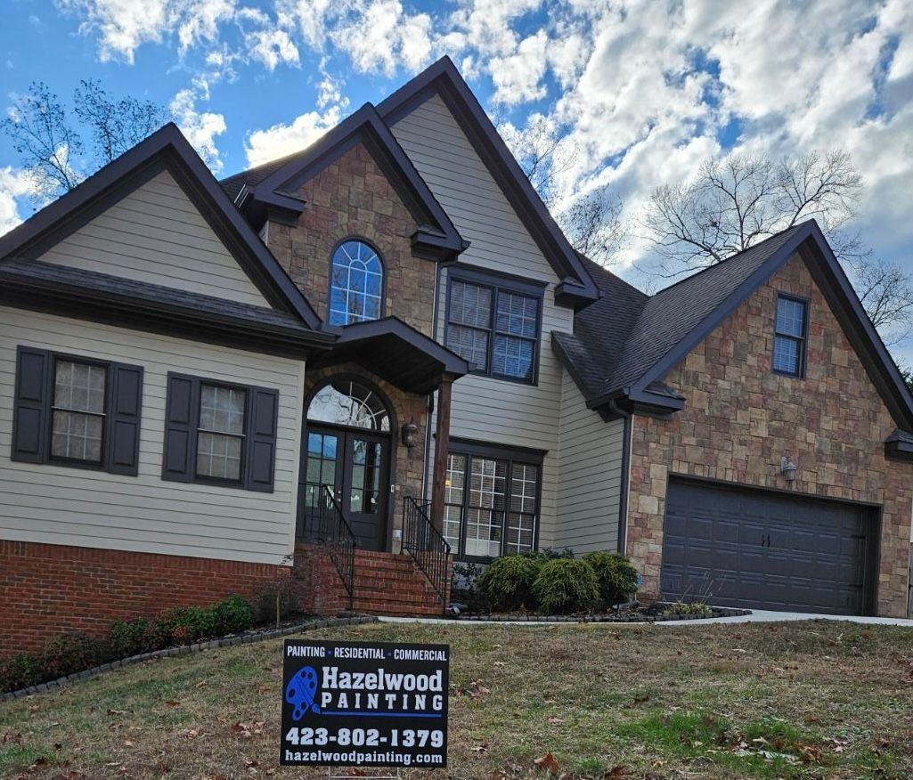 A large house with a sign that says ' hazelwood painting ' on it