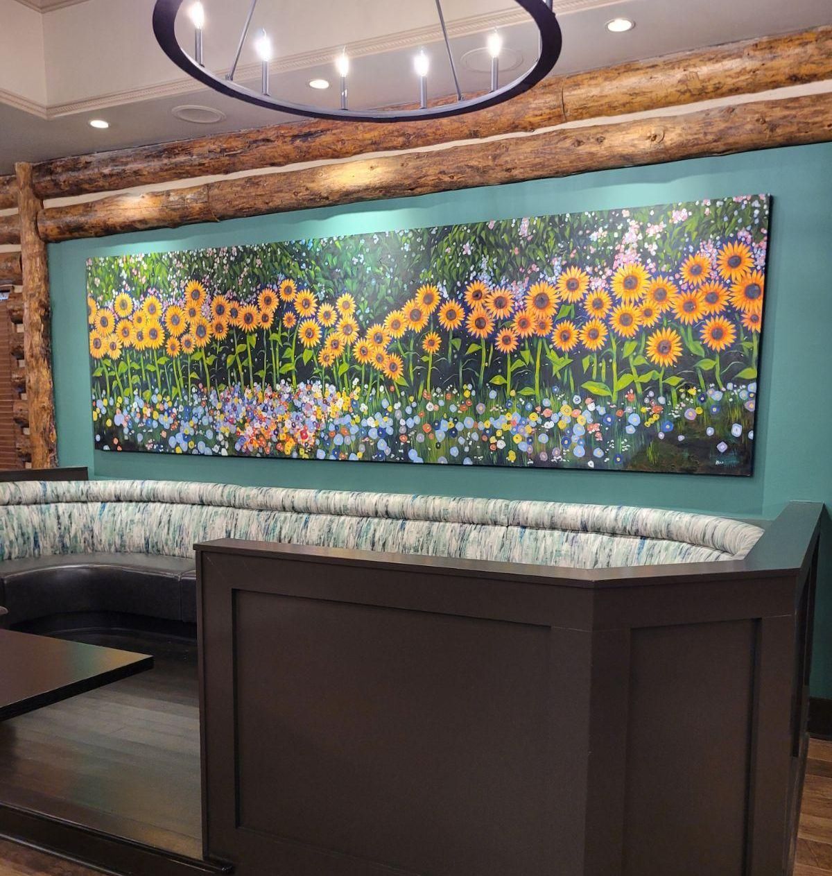 A living room with a couch and a large painting on the wall.