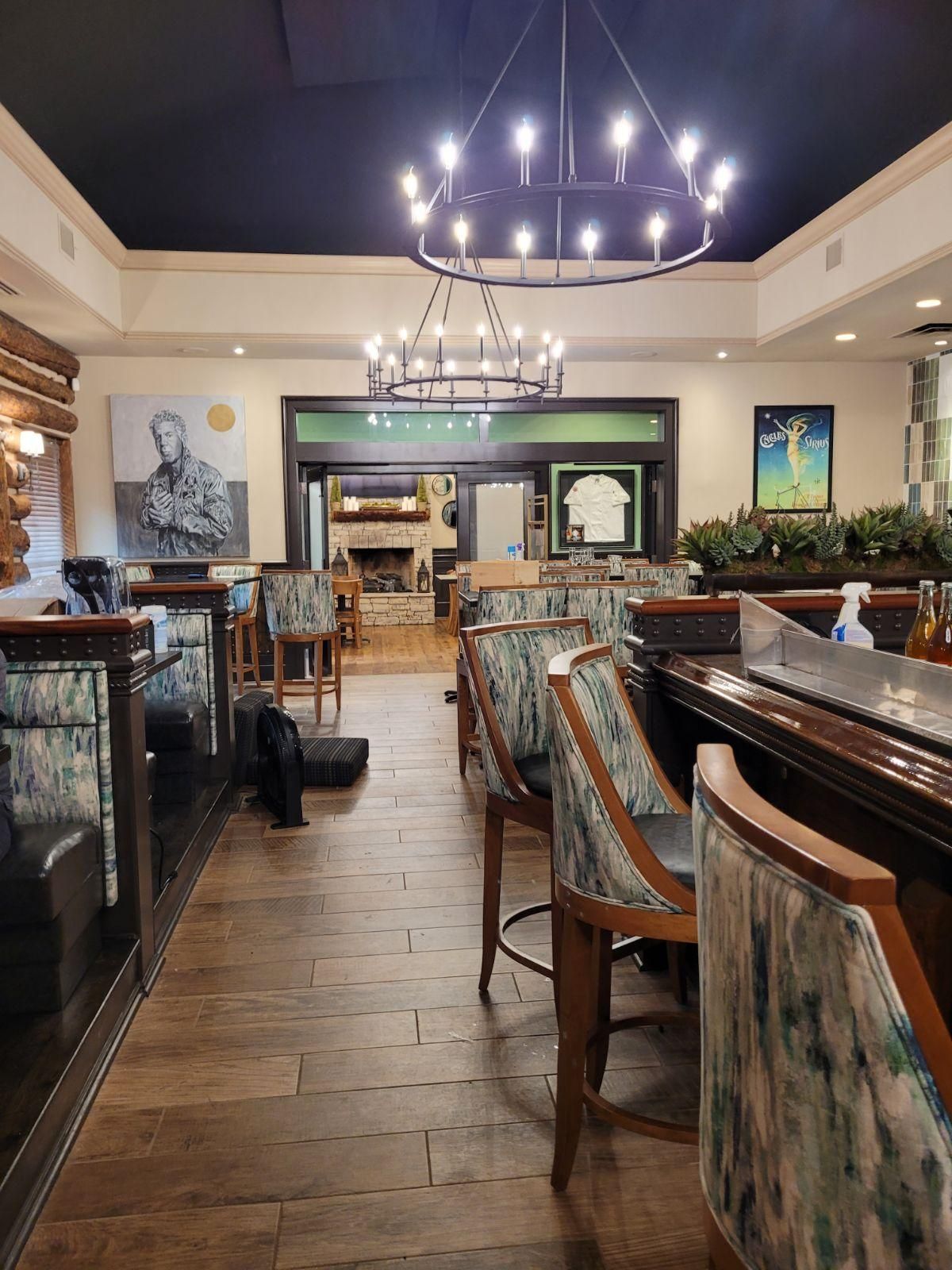 A restaurant with a lot of chairs and tables and a chandelier hanging from the ceiling.