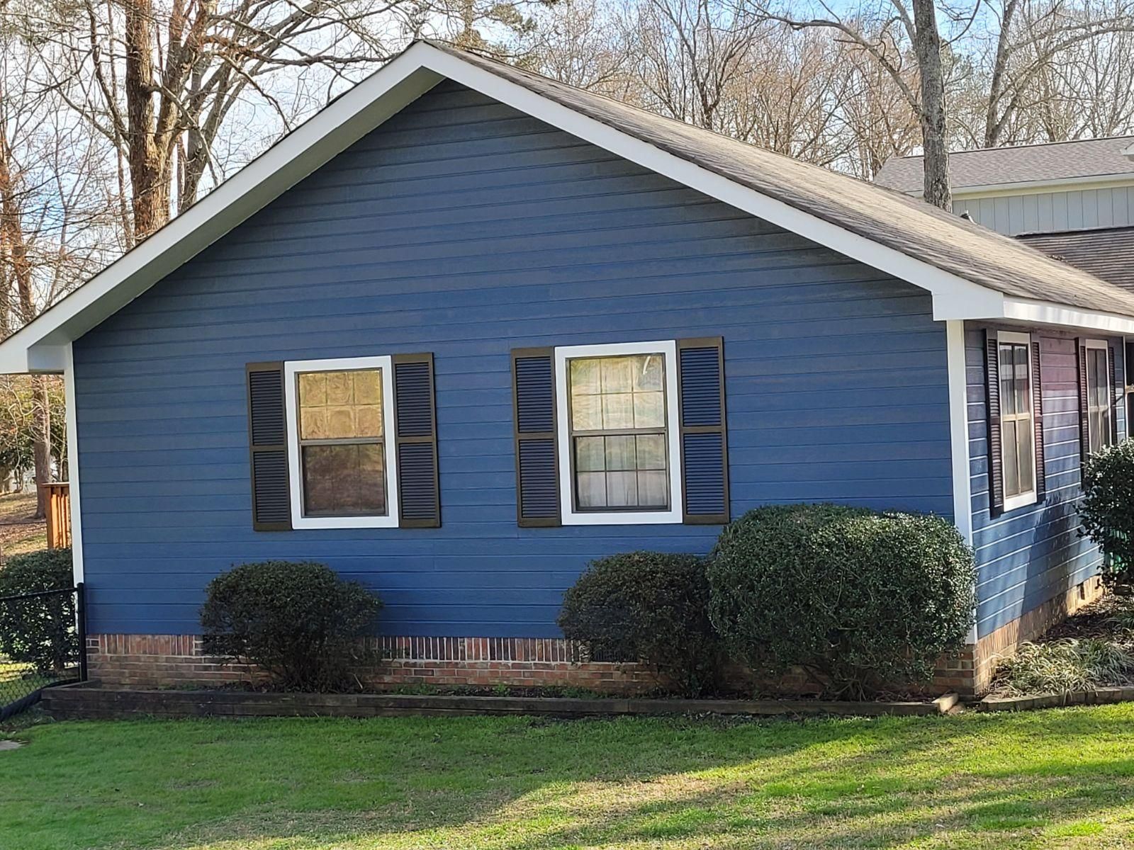 A blue house with a white trim and black shutters