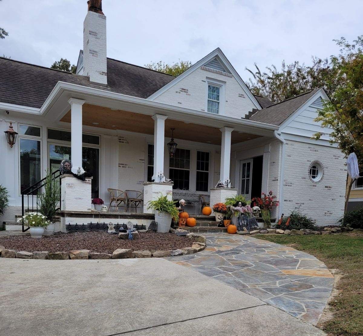 A large brick house with a black roof and lime wash brick.
