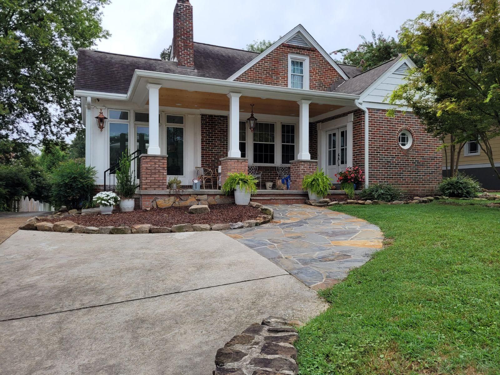 A brick house with a porch and a driveway