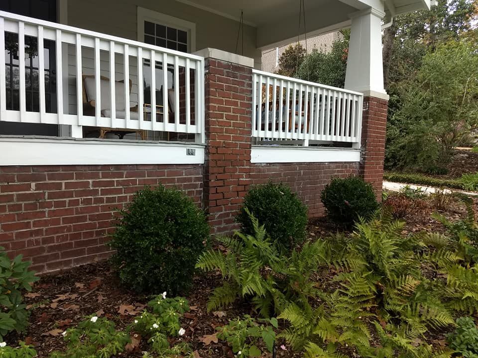 A brick house with a porch and a white railing