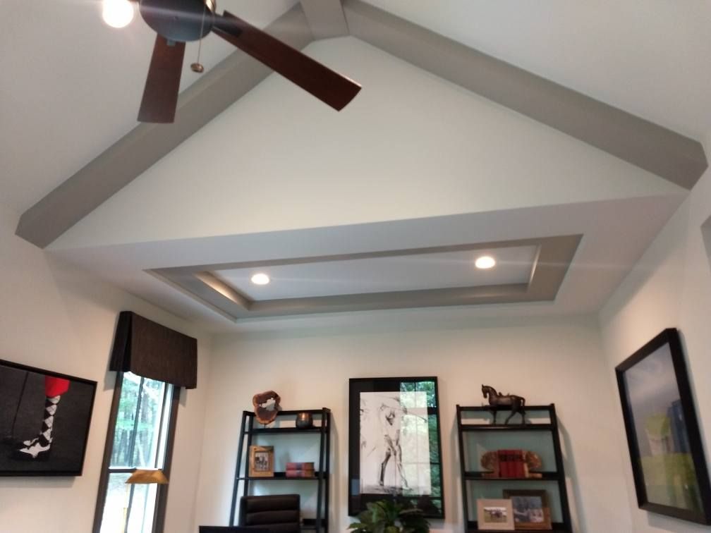 A living room with a vaulted ceiling and a ceiling fan