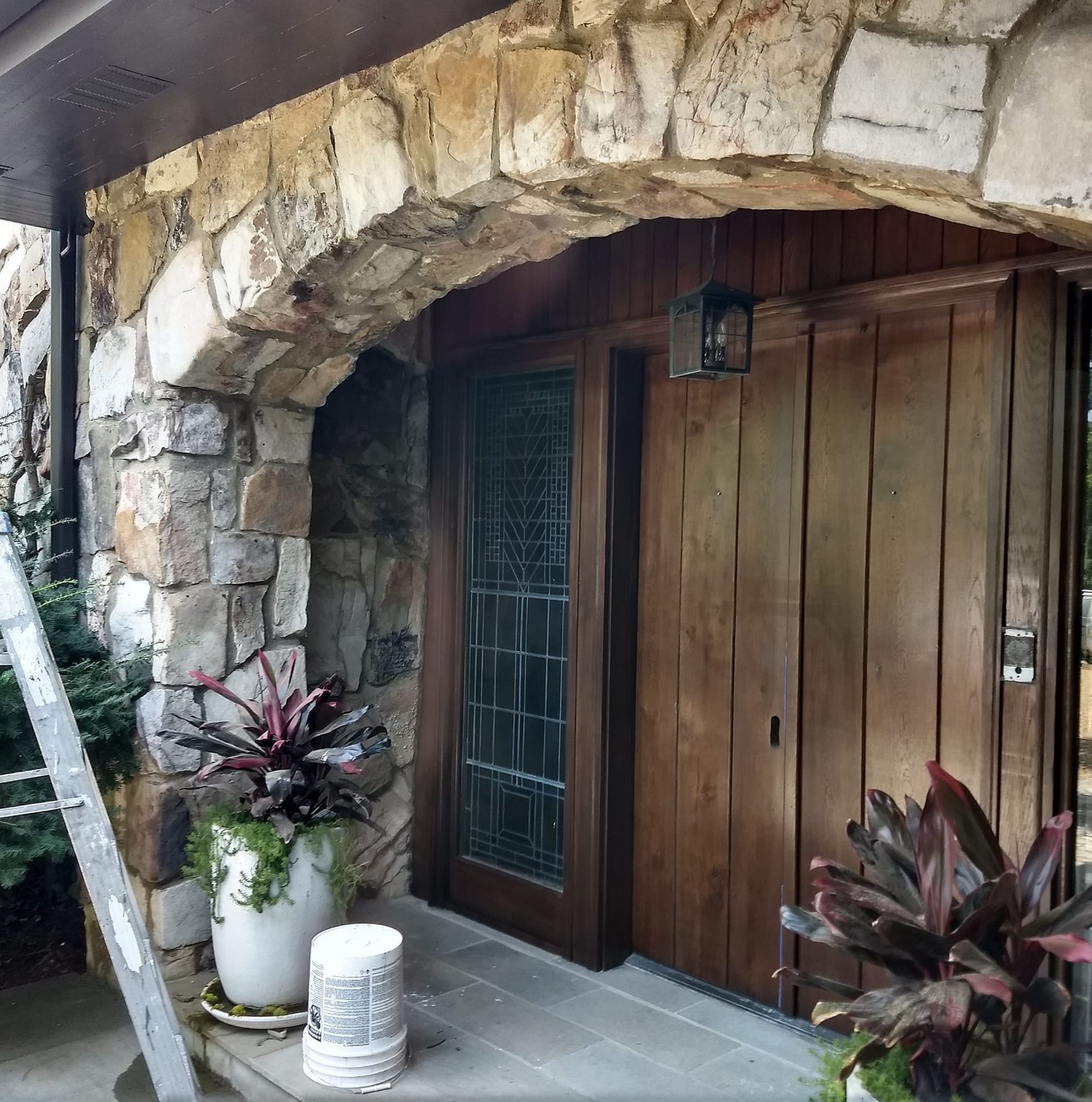 A stone building with a wooden door and a ladder