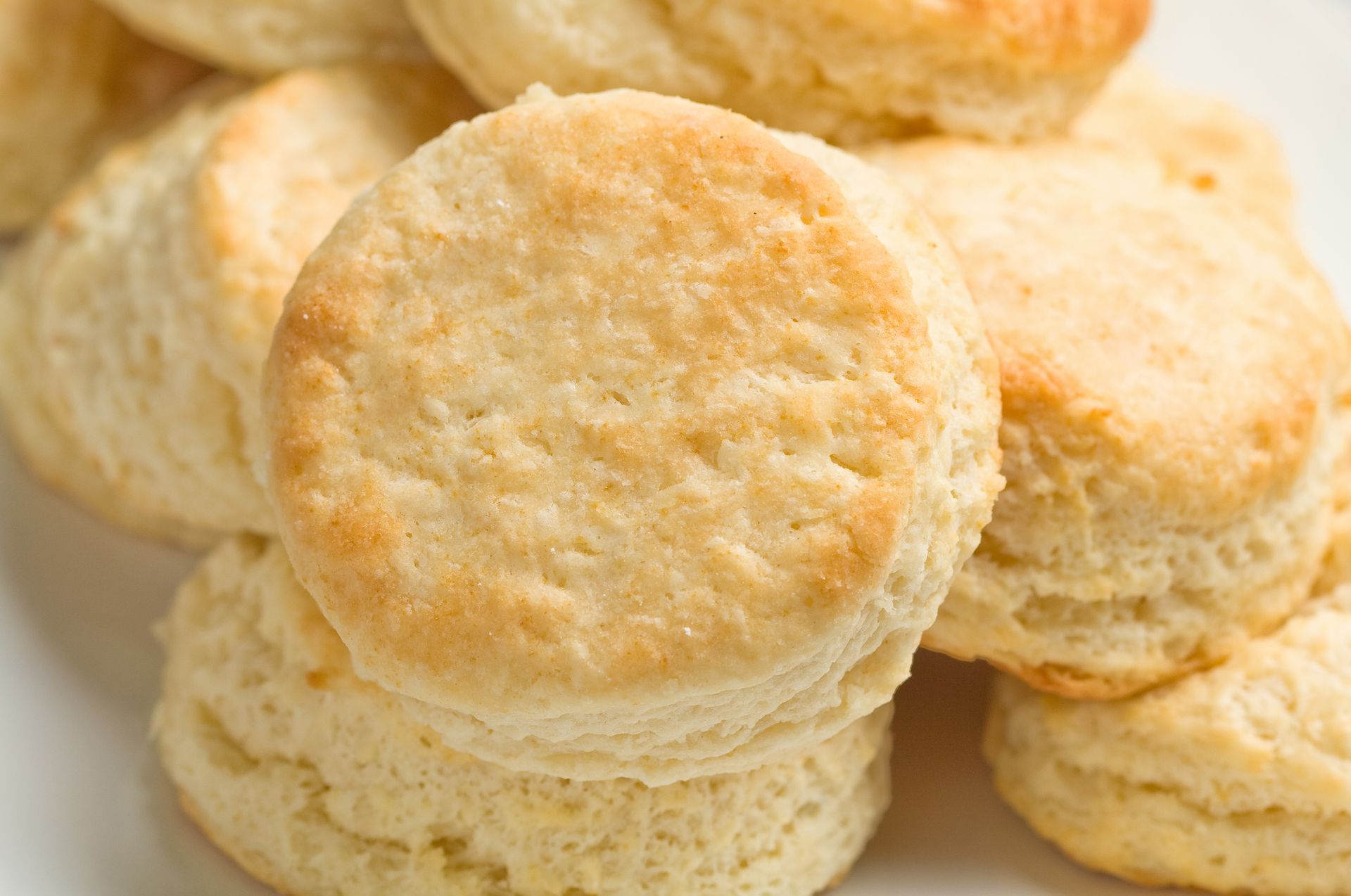 A pile of biscuits stacked on top of each other on a white plate.