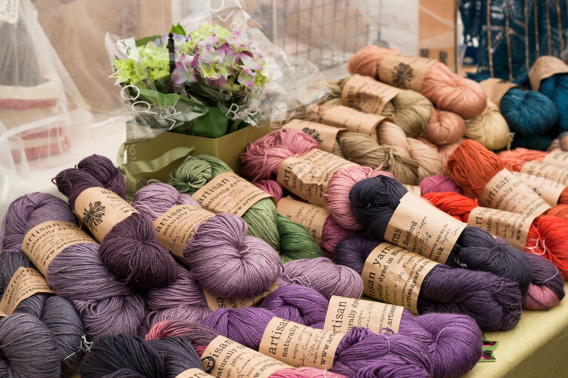 There are many different colored yarns on the table.