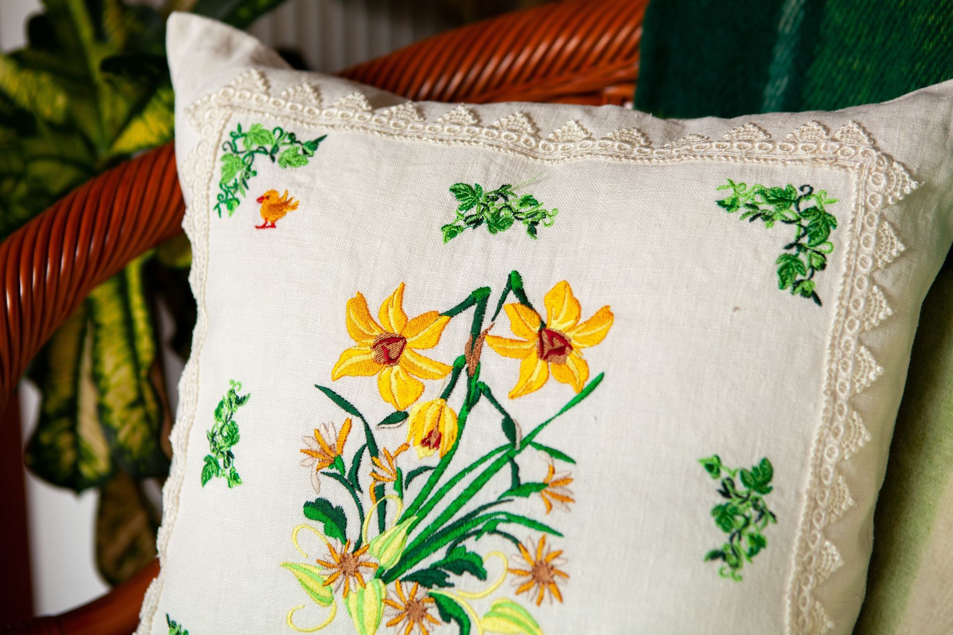 A pillow with flowers on it is sitting on a chair.