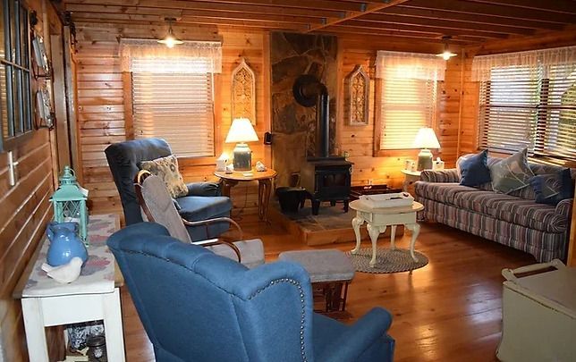 A living room filled with furniture and a wood stove.