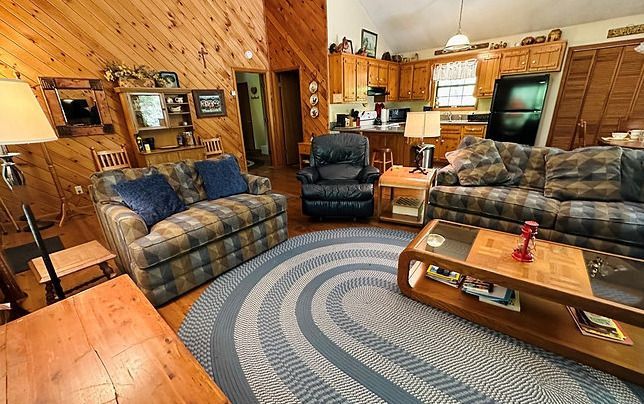 A living room with two couches , a coffee table , and a rug.