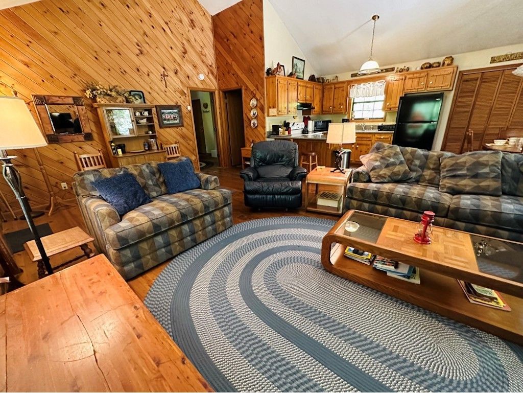 A living room with a couch , chair , coffee table and rug.