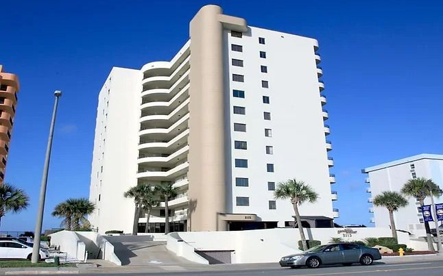 A white building with a car parked in front of it